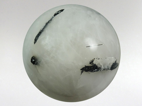 Beautiful white quartz sphere with rods of black tourmaline inclusions.