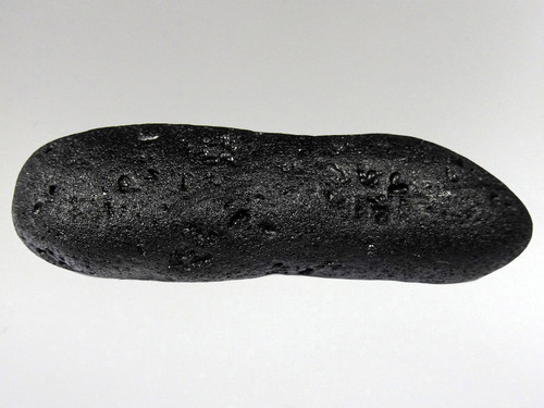 Tektites are natural glass rocks that are formed from terrestrial debris ejected during extraterrestrial impacts.