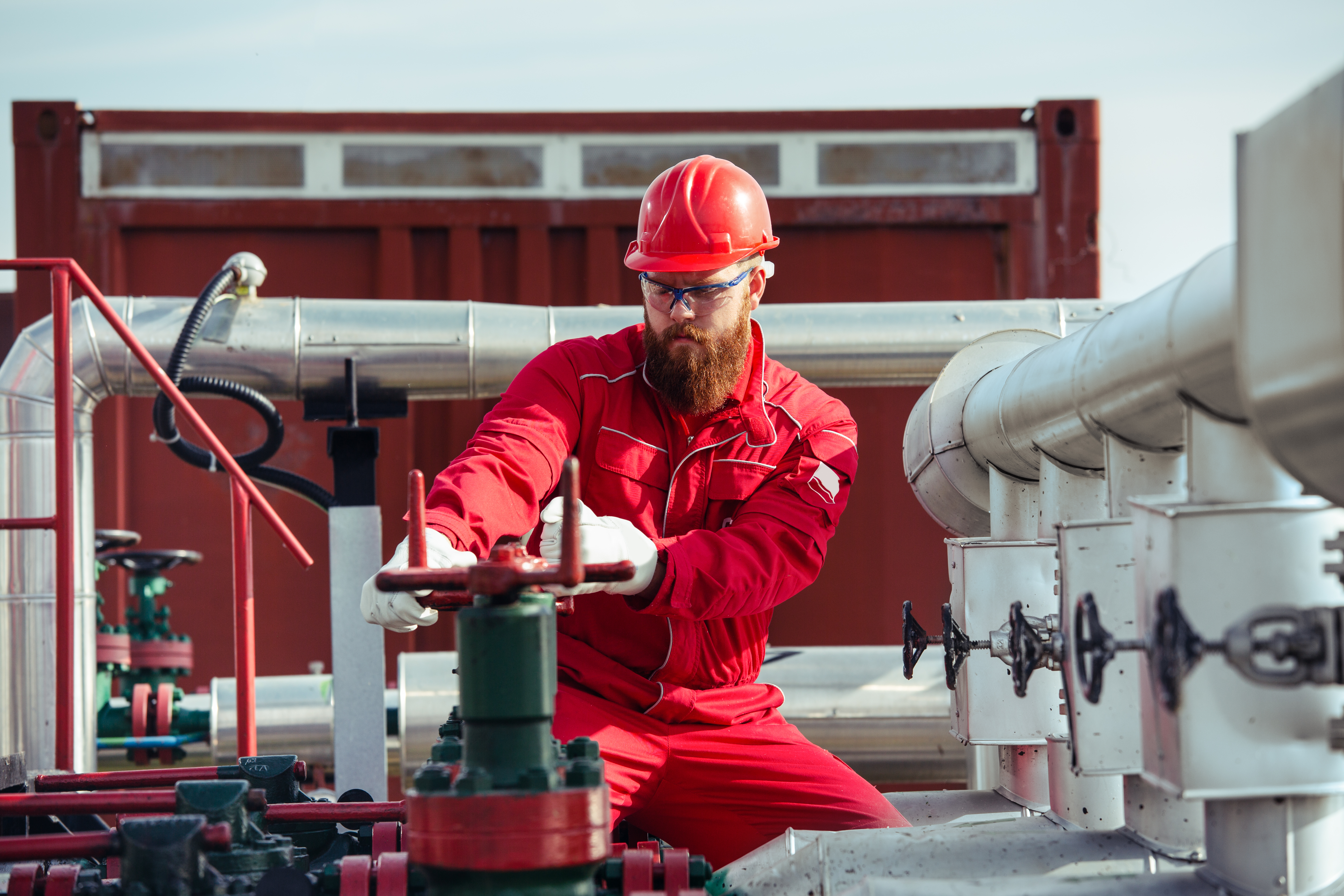 a person turning valve of pipe. this is a banner 