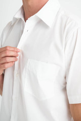 A white short sleeve button-up shirt featuring a chest pocket and a collar. The shirt has a subtle branding logo.
