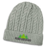A grey knit beanie with a cable pattern and a logo featuring trees on the front.