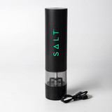 A rechargeable black pepper and salt grinder with a transparent base and USB charging cable. It features a logo.