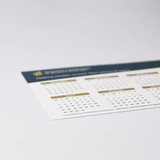 A magnetic calendar featuring a white background with gold accents, including dates for July and other months.