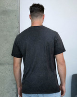 A dark charcoal grey t-shirt with a simple design, shown from the back on a model against a plain background.