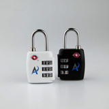 Two portable TSA luggage locks in white and black, featuring combination dials and a logo on each.