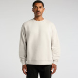 A light grey sweater on a man, featuring a relaxed fit and long sleeves. The garment has a logo on it.