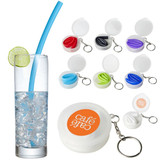 A drink bottle filled with ice, featuring a blue reusable silicone straw beside an assortment of coloured silicone straws in cases.