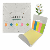 A sticky note pad featuring a floral design with yellow, pink, green, and orange note sections, in a speckled white holder.