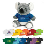 A grey koala plush toy wearing a blue shirt, surrounded by colourful shirts in various styles and colours.
