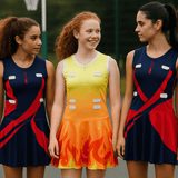 Three young women wear colourful netball dresses, featuring navy blue with red and orange designs, and one in yellow with flame motifs. Three young women wear colourful netball dresses, featuring navy blue with red and orange designs, and one in yellow with flame motifs.