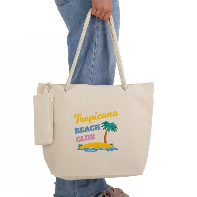 A creamy beige tote bag with a rope handle, featuring a tropical beach design and a detachable pouch.