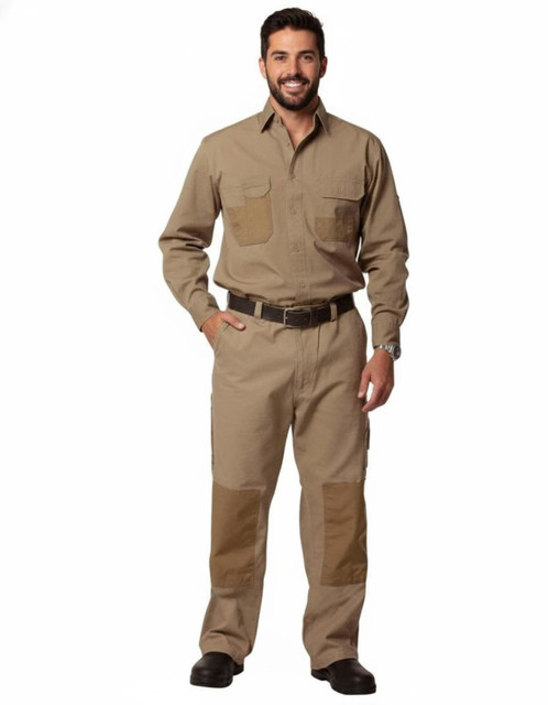 A man stands wearing khaki work pants with reinforced patches, accompanied by a matching shirt and belt, featuring a branding logo.