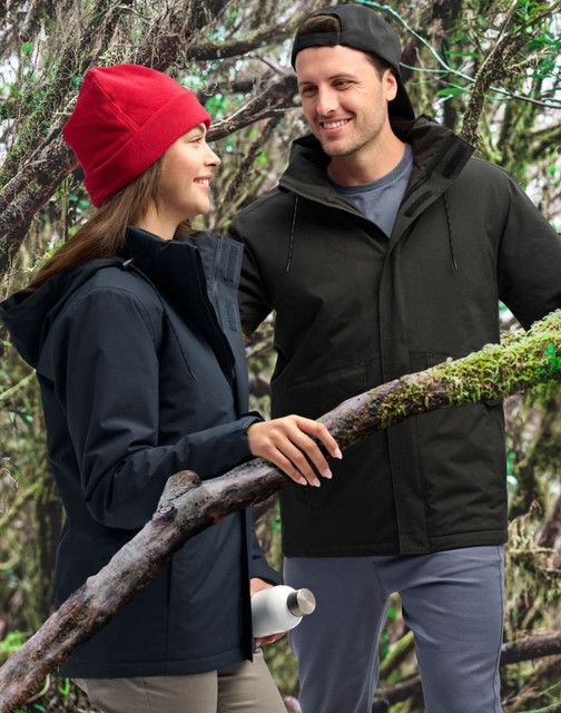 A unisex quilted waterproof jacket in navy and black, displayed by a man and woman in a forest setting.
