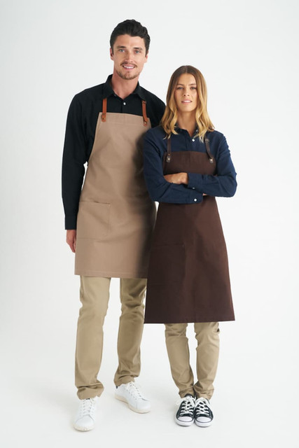A beige and brown bib apron is displayed on two models against a white background, showcasing a logo on the product.