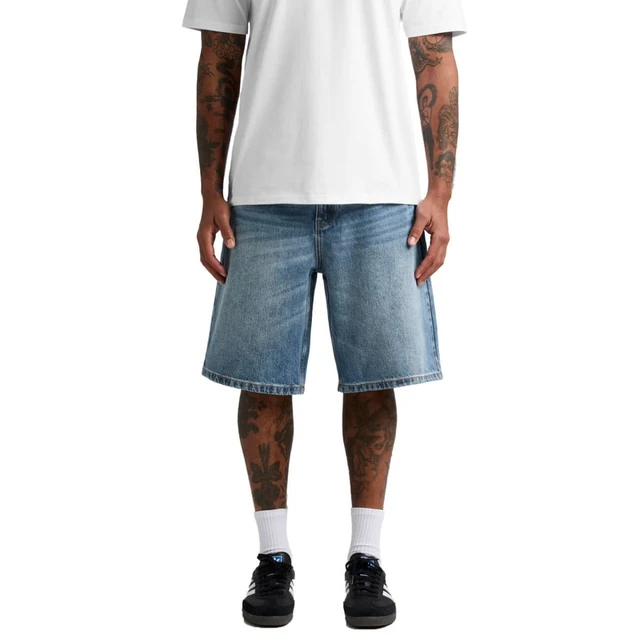 Denim shorts in light blue, featuring a relaxed fit and a stylish design, modelled on a person with tattoos.