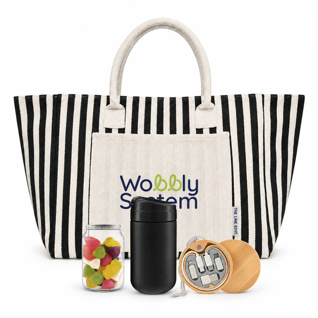 A striped tote bag in black and white with a cream pocket, a jar of colourful sweets, a black drink container, and a wooden item.