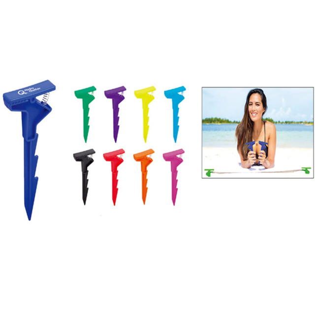 A blue Beach Clip alongside eight other colourful clips in various shades. The image features a person at the beach.