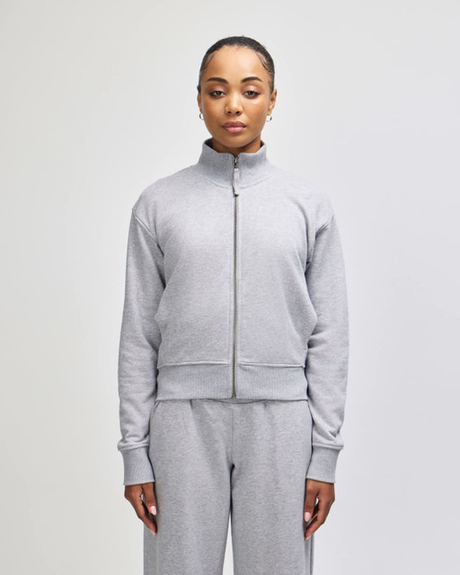 A grey full-zip jacket with a stand collar, featuring a fitted design and long sleeves. Contains a logo.