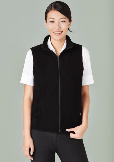 A black micro fleece vest with a zip, worn over a white shirt, featuring side pockets and a neckline zip.