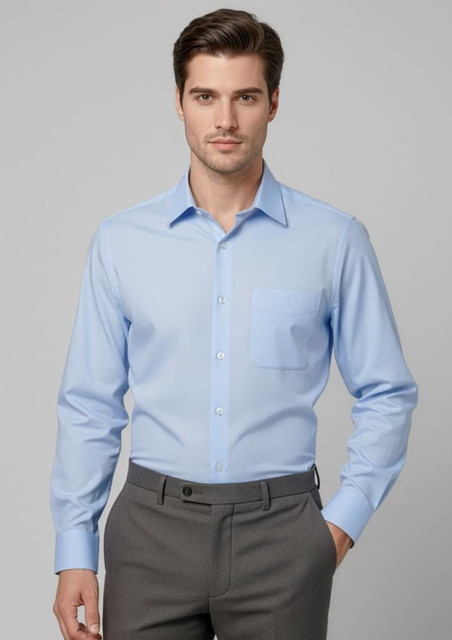 A light blue long sleeve button-up shirt with a chest pocket, paired with grey trousers. The model is standing neutrally.