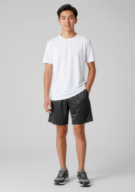 A model wearing black sports shorts and a white t-shirt, standing with hands in pockets. The shorts feature a logo.