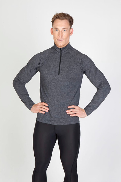 A man models a grey half zip mock neck jumper, featuring long sleeves and a fitted design.