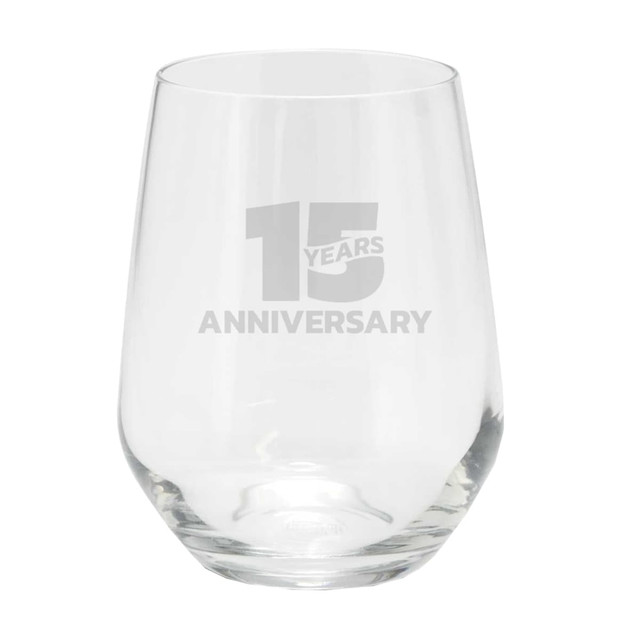 A stemless glass cup with a clear design, featuring a logo and a celebratory inscription for an anniversary.