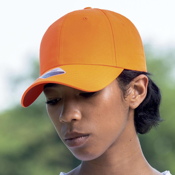 An orange cap on a person, featuring a logo on the front, set against a blurred outdoor background.