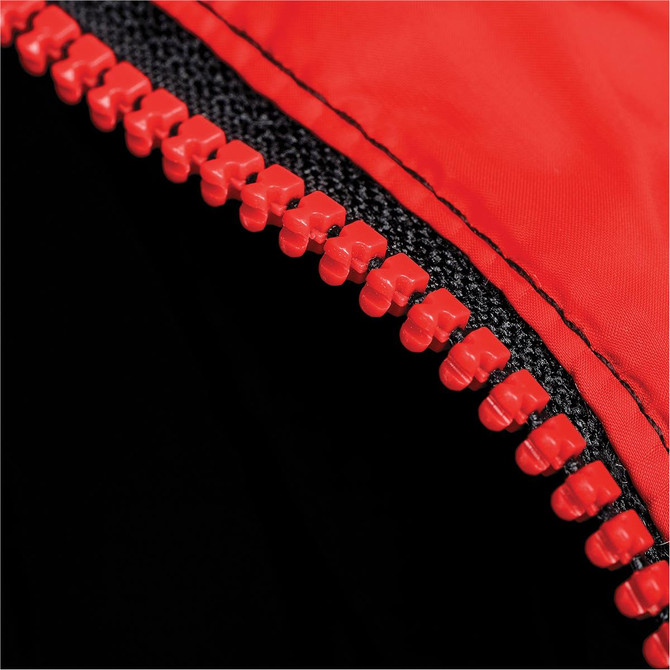 A close-up of a red zipper on a black puffer jacket with a textured fabric. The jacket features a logo.