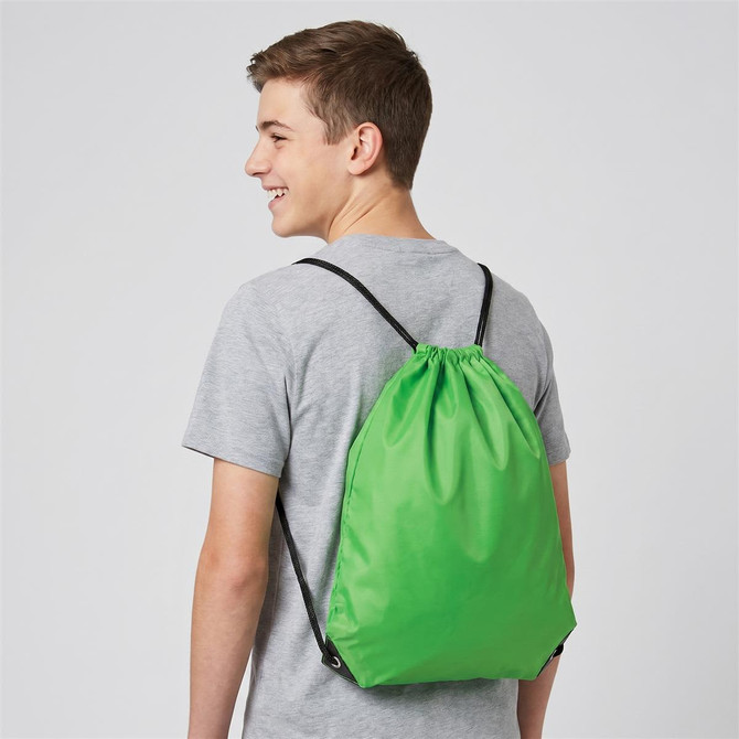 A green drawstring bag is worn on the back of a person, featuring black straps and a simple design.