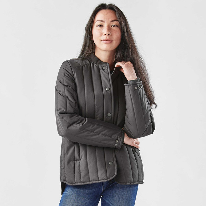 A women's thermal jacket in dark grey, featuring a button-up front and quilted design, with a logo on the sleeve.