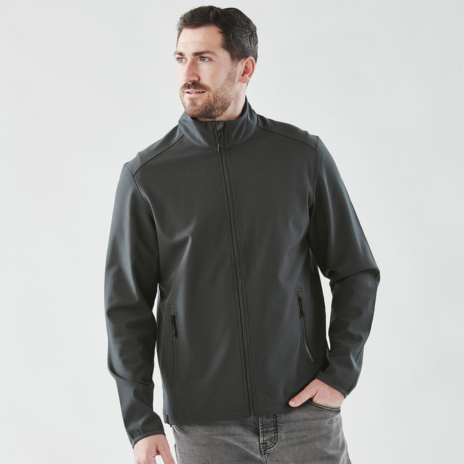 A men's softshell jacket in dark grey, featuring a zip front and side pockets, with a logo on the chest.