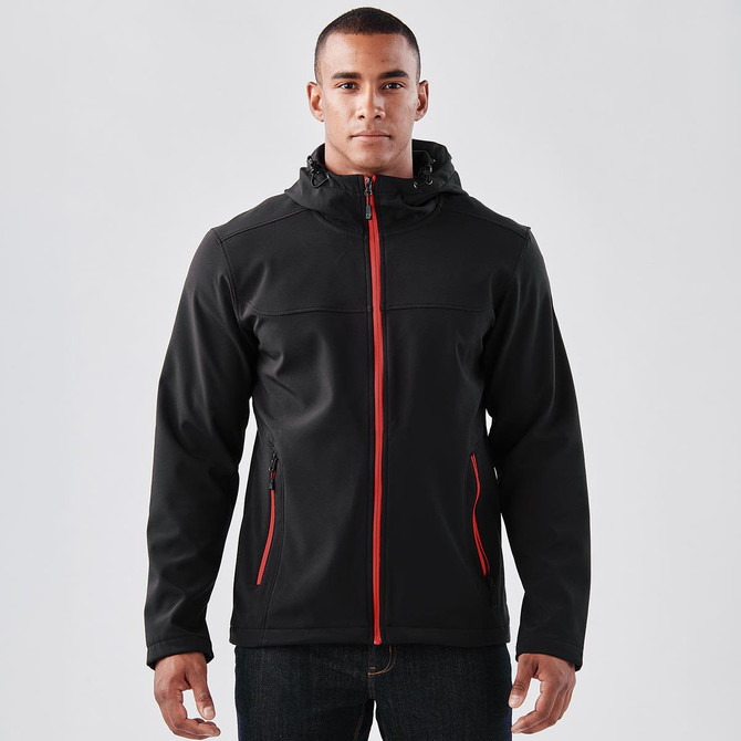 A black softshell hoody with red accents, featuring a zip front, zip pockets, and a hood. Includes branding.