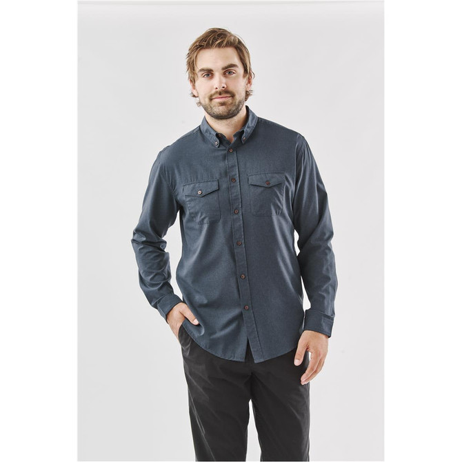 A man wearing a dark blue long-sleeve shirt with two chest pockets and a button-down collar.