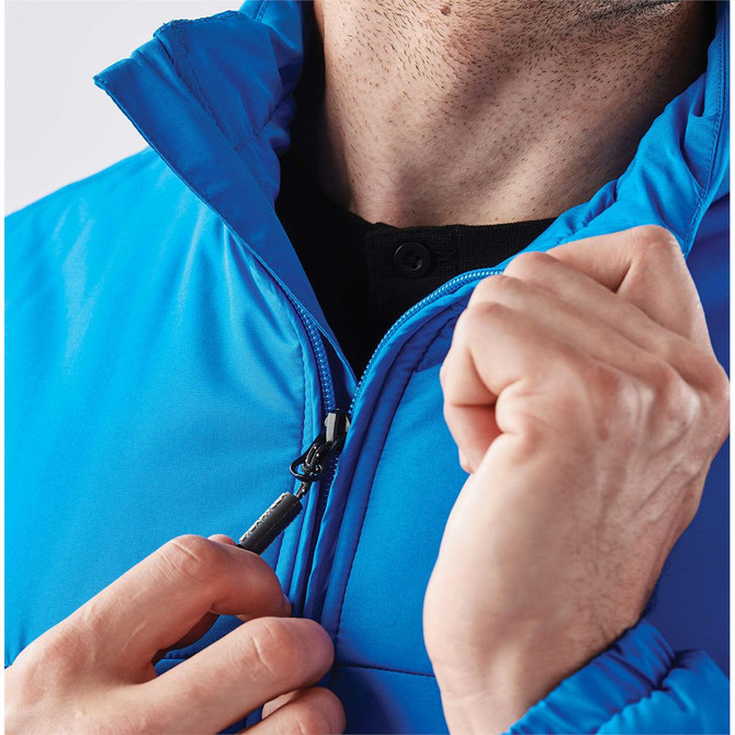 A vibrant blue quilted jacket with a zippered front and high collar, featuring a person adjusting the zipper.