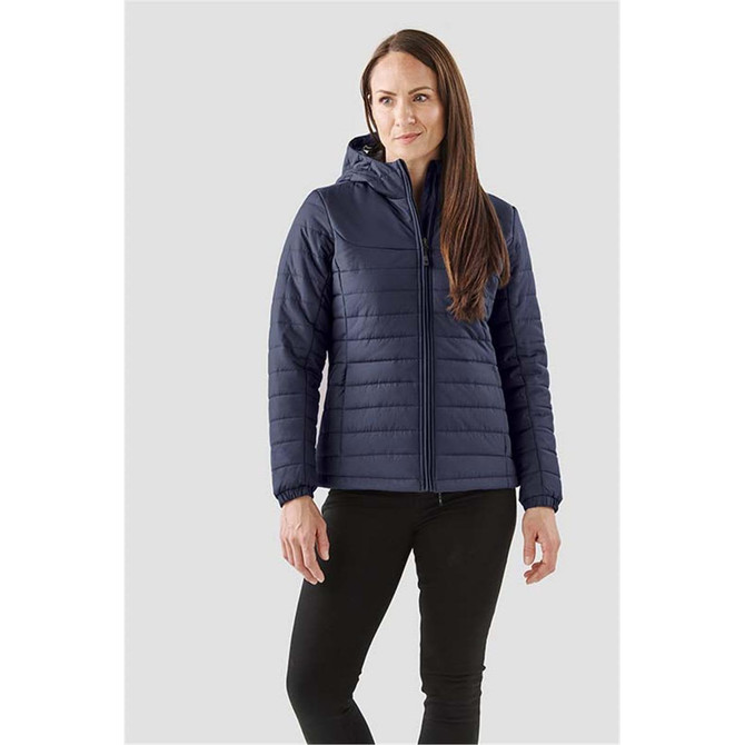 Navy blue women's quilted hoody with a front zip and hood, featuring a logo. Model stands against a neutral background.