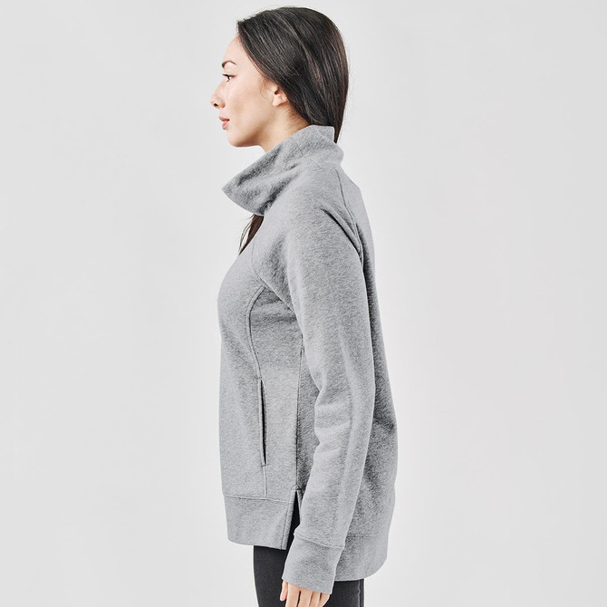 A grey women's cowl neck pullover jumper, featuring a high collar and side pockets, displayed on a model from the side.