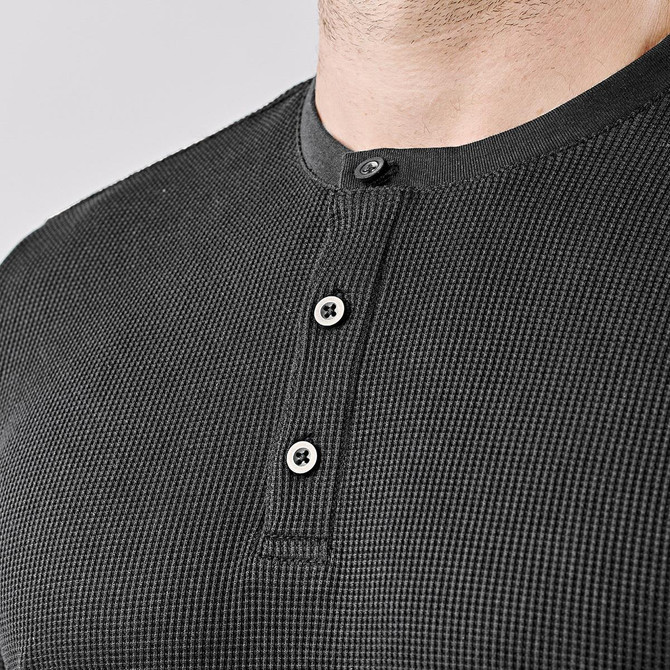 A black men's Ashburn Henley shirt with a buttoned neckline and textured fabric. Features a small logo.