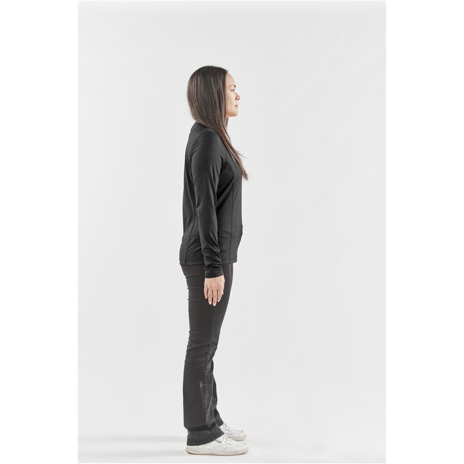 A side view of a woman wearing a black long-sleeve crew neck shirt and black pants, standing on a plain background.