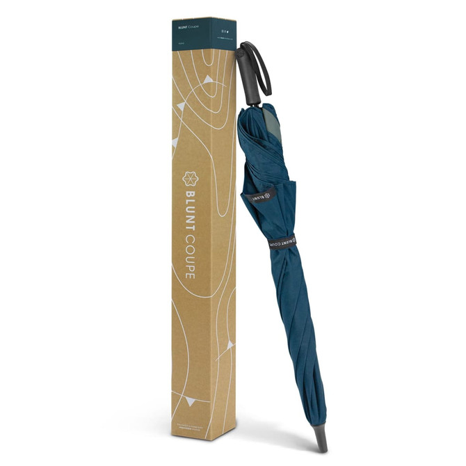 A teal BLUNT Coupe umbrella displayed upright in its protective packaging, featuring a logo on the box.