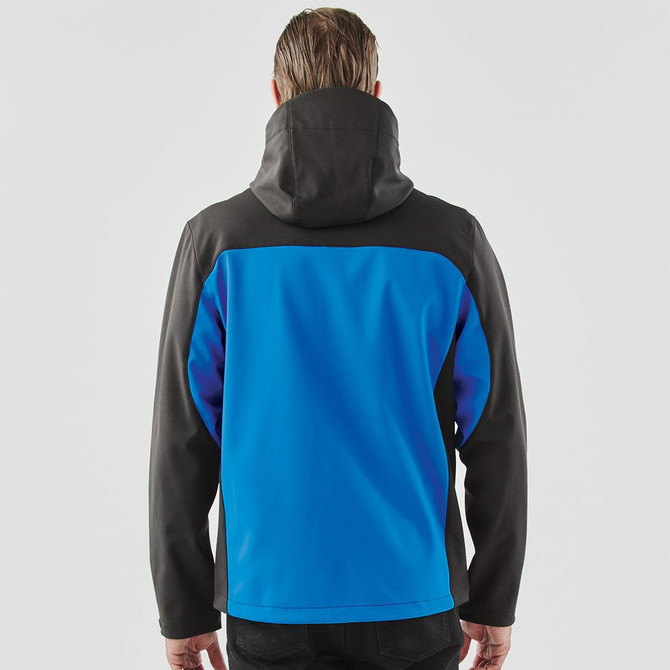 A hooded softshell jacket in blue and black, featuring a logo, viewed from the back.