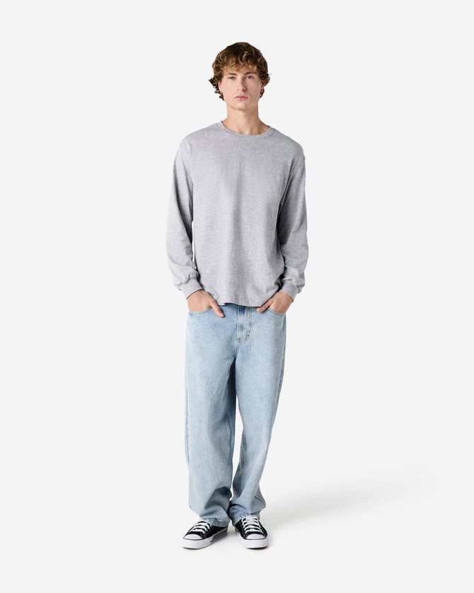 A grey heavyweight cotton unisex long sleeve T-shirt paired with light blue baggy jeans and black shoes.