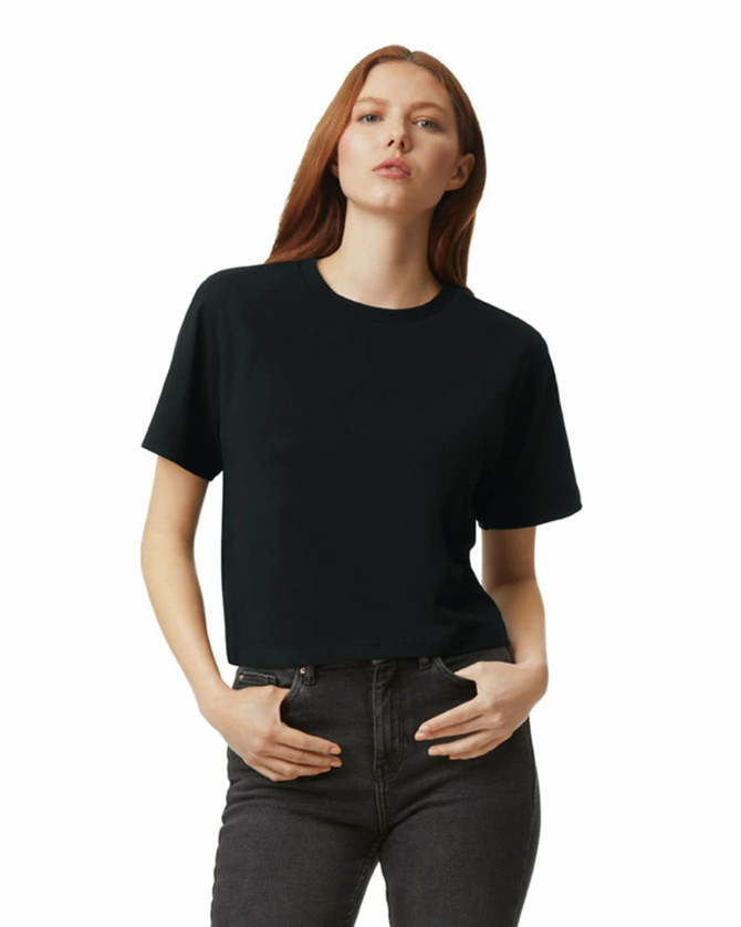 A black women's boxy T-shirt with short sleeves displayed on a model. The shirt has a logo on it.