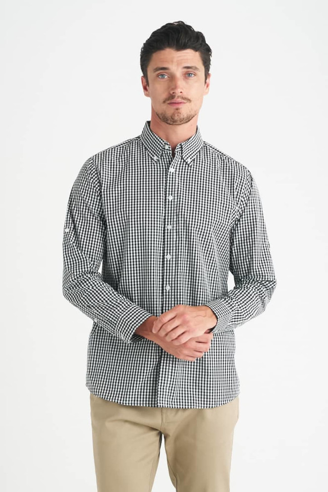 A long-sleeve, button-up shirt in a black and white gingham pattern, featuring a logo on the chest.