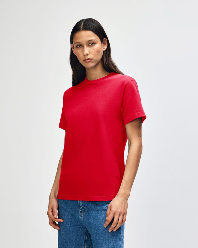 A red heavyweight cotton unisex T-shirt worn by a model, featuring a plain design and a logo.