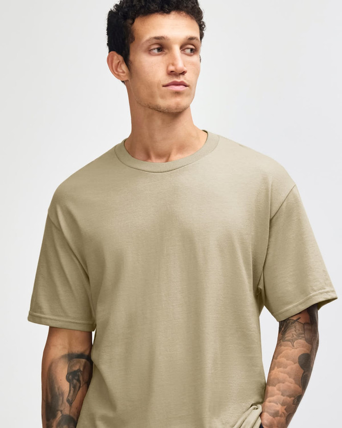 A heavyweight cotton unisex t-shirt in khaki, featuring short sleeves and a relaxed fit. It has a logo.