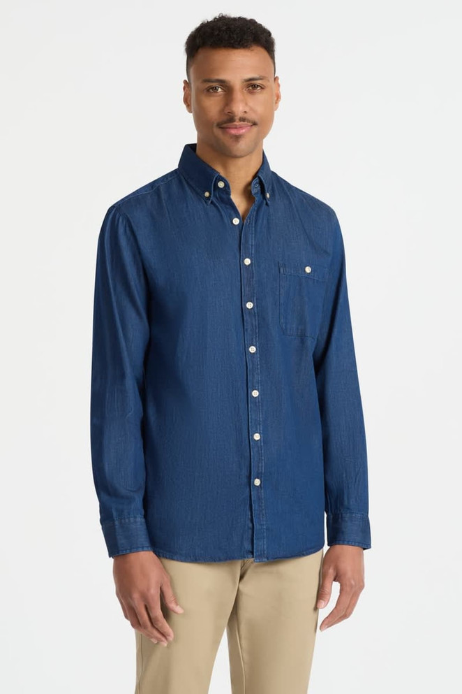 A mens long sleeve button-up shirt in a deep blue shade, featuring a chest pocket and white buttons.