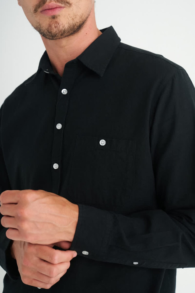 A black long sleeve button-up shirt with a chest pocket and buttons visible on the cuffs.