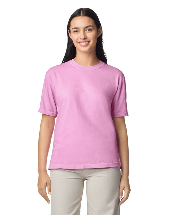 A pink adult heavyweight t-shirt displayed on a model, featuring short sleeves and a simple design.