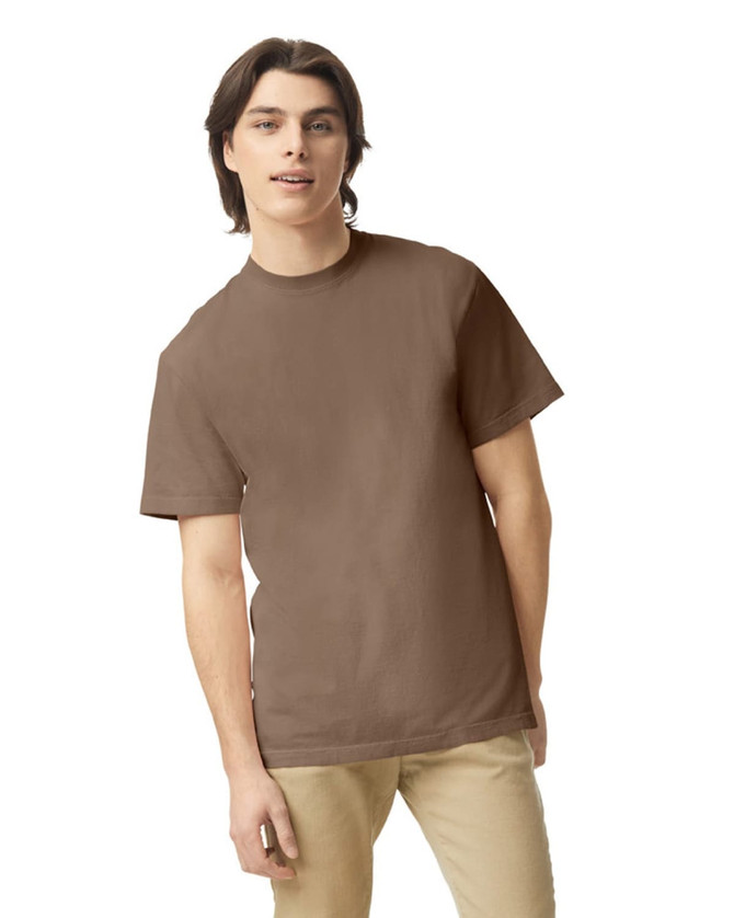 A brown heavyweight adult t-shirt on a model, featuring a casual fit and a plain design.